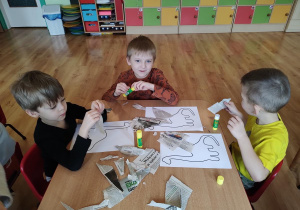 Dzieci wykonują pracę plastyczną "Dinozaur"
